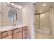 Bright bathroom featuring a vanity with sink and a shower-tub combo with sliding glass doors at 10529 Dacre Pl, Lone Tree, CO 80124