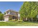 Beautiful two-story home with manicured lawn, mature trees, brick accents, and a two-car garage at 10529 Dacre Pl, Lone Tree, CO 80124