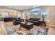 A bright living room has dark leather sofas and a large rug at 10529 Dacre Pl, Lone Tree, CO 80124