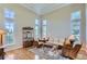 A living room has large windows, light hardwood floors and wicker seating at 10529 Dacre Pl, Lone Tree, CO 80124
