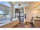 Light and bright main bathroom features a tiled soaking tub, glass shower and neutral vanity at 10529 Dacre Pl, Lone Tree, CO 80124