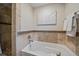 Clean bathroom featuring a soaking tub with tile surround and decorative tile accents at 395 Zephyr St, Lakewood, CO 80226
