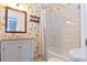 Bright bathroom with floral wallpaper, updated tiling, and a tub with shower at 5719 S Lowell Blvd, Littleton, CO 80123