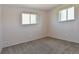 Neutral bedroom with gray carpet, two windows, and an electric baseboard heater at 5719 S Lowell Blvd, Littleton, CO 80123