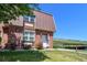 Inviting brick townhome featuring a unique roof, manicured lawn, and convenient parking at 5719 S Lowell Blvd, Littleton, CO 80123