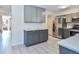Bright kitchen features stainless steel refrigerator, tiled flooring, granite countertops and gray cabinets at 5719 S Lowell Blvd, Littleton, CO 80123