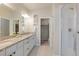 Well-lit bathroom features double sinks with granite countertops and a glass-enclosed shower at 19593 W 93Rd Ln # E, Arvada, CO 80007