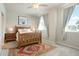 Inviting bedroom with a wooden bed frame, decorative rug, and large windows for natural light at 19593 W 93Rd Ln # E, Arvada, CO 80007