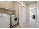 Functional laundry room featuring a modern washer and dryer set, along with shelving for convenient storage at 19593 W 93Rd Ln # E, Arvada, CO 80007