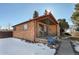 Brick ranch home with a covered porch and snowy front yard at 2990 Sheridan Blvd, Denver, CO 80214
