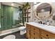 Stylish bathroom featuring a wood vanity, round mirror, and glass enclosed shower with green tiling at 1203 24Th St, Denver, CO 80205