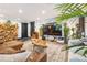 Living room with brick accent wall, decorative rug, modern furniture, and several plants at 1203 24Th St, Denver, CO 80205