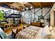 Open-concept main bedroom with hardwood floors, exposed wood beams, with two leather chairs at 1203 24Th St, Denver, CO 80205