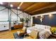Modern main bedroom with wood beams, hardwood floors, and a unique headboard design and two leather chairs at 1203 24Th St, Denver, CO 80205