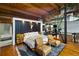 Modern main bedroom with wood beams, hardwood floors, and a unique headboard design and two leather chairs at 1203 24Th St, Denver, CO 80205