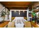 Modern main bedroom with wood beams, hardwood floors, and a unique headboard design and two leather chairs at 1203 24Th St, Denver, CO 80205
