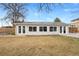 Back exterior view of the home featuring a spacious yard, patio, and large windows at 1359 Chambers Rd, Aurora, CO 80011