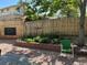 Backyard featuring a brick planter, wooden fence, gravel area, and mature shade trees at 1359 Chambers Rd, Aurora, CO 80011