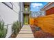 Modern home featuring a stone walkway, a yellow front door, and privacy landscaping at 2223 W 34Th Ave, Denver, CO 80211