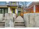 View of the modern home's entrance with concrete stairs, gated walkway, and vibrant yellow door at 2223 W 34Th Ave, Denver, CO 80211