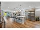 Bright, open kitchen with stainless steel appliances, quartz countertops, and a large island at 2223 W 34Th Ave, Denver, CO 80211