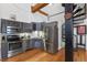 Modern kitchen featuring gray cabinetry and stainless steel appliances, complemented by an adjacent spiral staircase at 1555 California St # 414, Denver, CO 80202