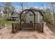 Secluded backyard with custom swing and seating area, mature trees, and well-maintained landscaping at 7676 S Olive Cir, Centennial, CO 80112