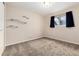 Neutral bedroom with large window, floating shelves and carpeted floors provides a blank canvas at 7676 S Olive Cir, Centennial, CO 80112