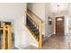Welcoming entryway with tiled floor, wood door, and a staircase featuring wooden handrails and iron balusters at 7676 S Olive Cir, Centennial, CO 80112