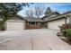 Charming exterior showcasing a well-maintained lawn and a two-car garage with stone detailing along the facade at 7676 S Olive Cir, Centennial, CO 80112