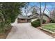 Inviting home exterior with a stone accent wall, lush landscaping, and a spacious driveway leading to the garage at 7676 S Olive Cir, Centennial, CO 80112