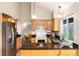 A bright kitchen with wood cabinets, granite countertops, stainless steel appliances, and a breakfast nook at 7676 S Olive Cir, Centennial, CO 80112
