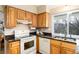 A charming kitchen featuring wooden cabinets, granite countertops, and a window providing natural light at 7676 S Olive Cir, Centennial, CO 80112
