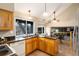 Bright kitchen featuring granite countertops, wood cabinets, and a seamless connection to the dining and living areas at 7676 S Olive Cir, Centennial, CO 80112