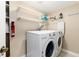 Bright laundry room with front load washer and dryer, open shelving, and ironing station at 7676 S Olive Cir, Centennial, CO 80112