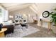 Comfortable living room with vaulted ceilings, a modern sofa and accent chairs on a patterned area rug at 7676 S Olive Cir, Centennial, CO 80112
