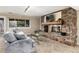 Comfortable living room featuring a stone fireplace, and a large window offering a view of the yard at 7676 S Olive Cir, Centennial, CO 80112