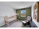 Serene Bedroom with a wooden crib, glider chair, and a calming color palette, perfect for a peaceful retreat at 4782 E Costilla Ave, Centennial, CO 80122