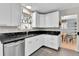 Efficient kitchen with white cabinets, modern appliances, and black backsplash at 4782 E Costilla Ave, Centennial, CO 80122