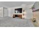 Spacious living room with a TV, brick fireplace, and neutral decor, perfect for entertainment and relaxation at 4782 E Costilla Ave, Centennial, CO 80122