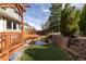 Landscaped backyard with tiered garden beds and serene pond feature at 11932 W 56Th Cir, Arvada, CO 80002