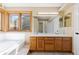 Bathroom with a double vanity, tile countertop, and a view into the shower area at 11932 W 56Th Cir, Arvada, CO 80002
