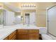 Bright bathroom with a double sink vanity, large mirror, and shower with glass door at 11932 W 56Th Cir, Arvada, CO 80002