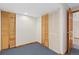 Bedroom with floral wallpaper, blue carpet, and built-in closet storage at 11932 W 56Th Cir, Arvada, CO 80002