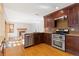 This kitchen features dark wood cabinets, stainless steel appliances and hardwood floors at 11932 W 56Th Cir, Arvada, CO 80002