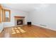 Bright living room featuring hardwood floors and a brick fireplace at 11932 W 56Th Cir, Arvada, CO 80002