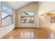 Spacious living room with hardwood floors, large windows, and high ceilings, showcasing abundant natural light at 11932 W 56Th Cir, Arvada, CO 80002