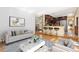 Open-concept living area with wood floors, a kitchen with counter seating, and modern furnishings at 11932 W 56Th Cir, Arvada, CO 80002