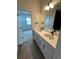 Dual vanity with white cabinets and black fixtures, open to a bedroom with lots of natural light at 191 Washington St, Erie, CO 80516