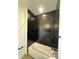 Modern bathtub with black tiled wall and dark hardware, offering a sleek design at 191 Washington St, Erie, CO 80516